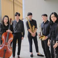 Five musicians wearing all black holding cello, saxophone, trombone, and clarinet