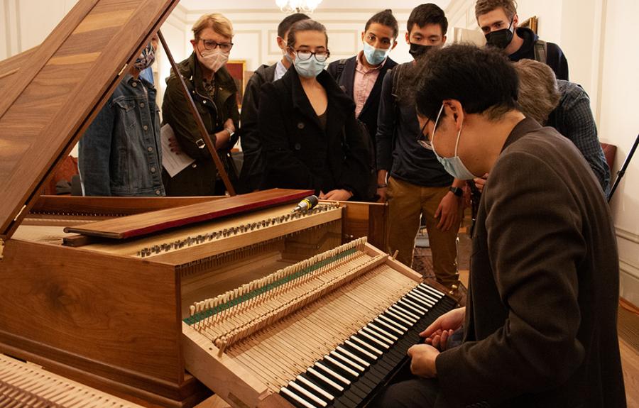 Mike Lee shows the inner workings of a keyboard instrument while students look on