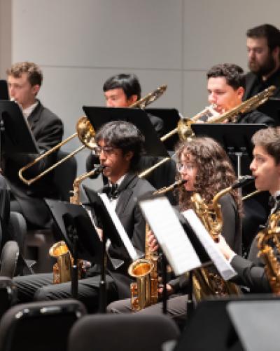 Wind symphony members play instruments